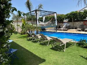 a group of chairs sitting next to a swimming pool at Grand Alaçatı Butik Hotel in Alaçatı