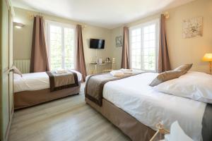 a bedroom with two beds and two windows at Logis Hôtels - Hôtel Restaurant Domaine Les Falaises in Martel