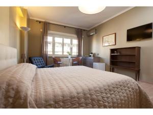 Schlafzimmer mit einem großen weißen Bett und einem Schreibtisch in der Unterkunft Alex's Guest House in Rom