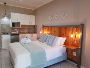 a bedroom with a large bed and a kitchen at CasaMere in Vanderkloof