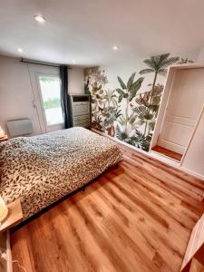a bedroom with a bed and a wall with a mural at Maison T3 2CH Climatisée Terrasse parking gratuit in Saint-Julien-les-Villas