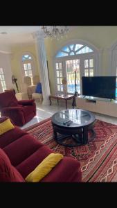 アレクサンドリアにあるVilla rosy north coastのリビングルーム(赤いソファ、コーヒーテーブル付)