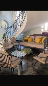 アレクサンドリアにあるVilla rosy north coastのソファと螺旋階段のあるリビングルーム