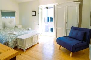 Un dormitorio con una cama y una silla azul. en Rustico in pietra, en Brissago