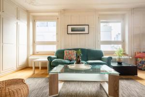 チューリッヒにあるKAYA Apartment TURQUOISE - Downtown 3BR Deluxe Aptの緑のソファとテーブルのあるリビングルーム
