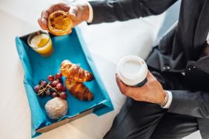 a man holding a drink and a plate of food at Stay Hotel Porto Centro Trindade in Porto