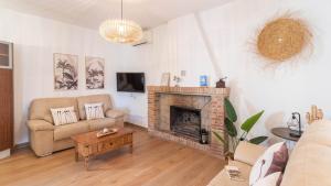 salon z kanapą i kominkiem w obiekcie Villa Gran Solano Colmenar by Ruralidays w mieście Colmenar
