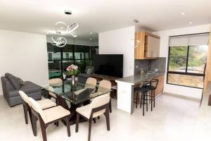 Una cocina y una sala de estar con una mesa de cristal y sillas. en MV Departamento 2, en Baños