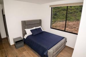 Un dormitorio con una cama grande con ventana. en MV Departamento 2, en Baños