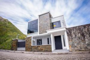una casa en una colina con una pared de piedra en MV Departamento 2, en Baños