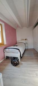 a bedroom with a bed in a pink wall at Chalet BORGO PRA' in Belluno