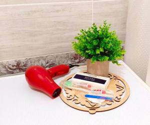 a table with a plate with a plant and a hot dog at 12 Microragion Apartments in Aktobe
