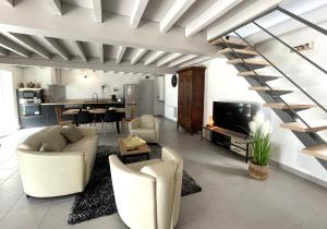 Una sala de estar con un sofá y una escalera. en Lendre, en Méritein