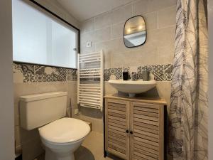 Un baño con inodoro, lavabo y espejo. en Lendre, en Méritein