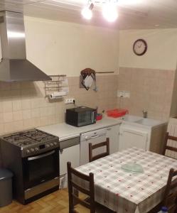 kuchnia z kuchenką i stołem nakrytym obrusem w obiekcie Les VIGNEAUX Hautes Alpes, Appartement 4 personnes, avec belle terrasse panoramique w mieście Les Vigneaux