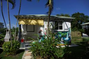 a small white house with graffiti on it at Bungalow charmant à Sainte-Rose avec terrasse et piscine in Sainte-Rose
