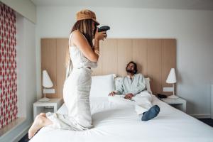 a woman standing on a bed next to a man at Stay Hotel Porto Centro Trindade in Porto
