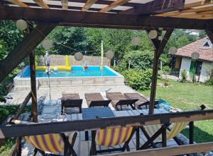 a backyard with a pool with chairs and a table at Vikendica Vučetić Loznica in Budimlija