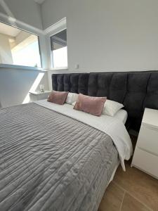 a large bed with a black headboard in a bedroom at Innova TravelVir - Villa SunSet in Privlaka +77 photos
