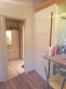 Habitación con mesa, puerta y cocina. en le logis en bois, en Saint-Mathieu-de-Tréviers 11 fotos más