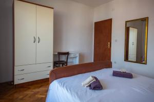 a bedroom with a bed with a mirror and a dresser at Bepo i Marija A2 in Pag +5 photos