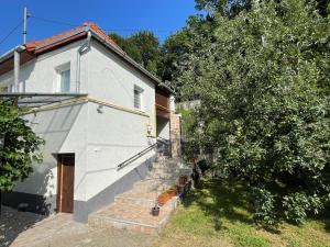 een wit huis met een trap naast een boom bij FLH - Casa Gheti in Sighişoara