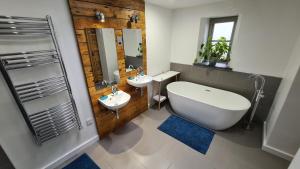 a bathroom with two sinks and a large tub and a tub at Snowdonia Glamping Holidays, Betws-y-Coed in Betws-y-coed +43 photos