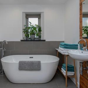 a bathroom with a white tub and a sink at Snowdonia Glamping Holidays, Betws-y-Coed in Betws-y-coed
