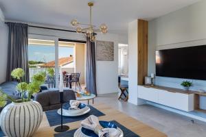 a living room with a large flat screen tv at Salt Bloom Apartments Nin in Nin