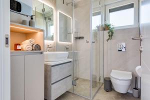 a bathroom with a shower and a toilet and a sink at Salt Bloom Apartments Nin in Nin +79 photos