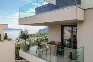 una casa con un balcón con una mesa y sillas en Appartement Carpe Diem, en Ičići 14 fotos más