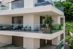 Un edificio de apartamentos con un balcón con mesa y sillas. en Appartement Carpe Diem, en Ičići