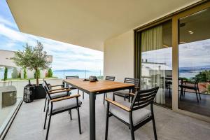 Un comedor con mesa y sillas en un balcón. en Appartement Carpe Diem, en Ičići