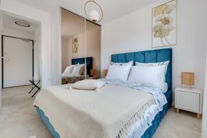 a bedroom with a large bed with a blue headboard at Salt Bloom Apartments Nin in Nin