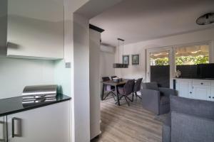 a living room and kitchen with a table and chairs at Rosie in Valbandon