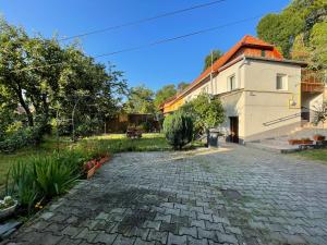 a house with a brick driveway next to a building at FLH - Casa Gheti in Sighişoara