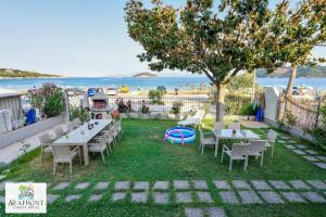 a patio with tables and chairs and the beach at SeafrontGardenHouse Villa in Iraklitsa +56 photos