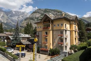 a building with a hotel in front of a mountain at Hotel Bouton d'Or - Courmayeur in Courmayeur