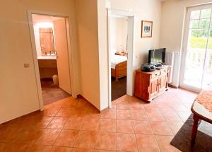 a living room with a television and a bedroom at Ostseewelle 5 in Kühlungsborn