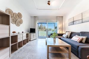 un soggiorno con un divano e un tavolo di MalagaSuite Marbella Pool Paradise a Marbella