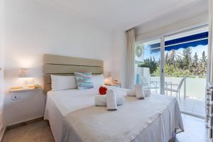 una camera da letto con un letto grande e un balcone di MalagaSuite Marbella Pool Paradise a Marbella Altre 22 foto