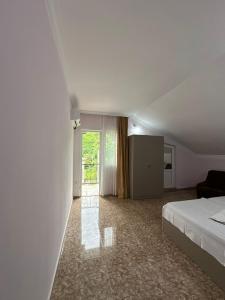 a white room with a bed and a window at Shamil House in Makhinjauri