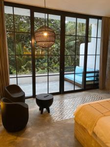 a bedroom with a bed and a chair and a lamp at The CIVYT in Ubud
