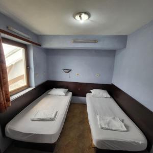 two beds in a small room with a window at Hostel Varna Botanika in Varna City