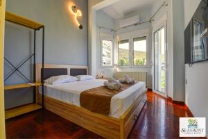 a bedroom with a large bed in a room with windows at SeafrontGardenHouse Villa in Iraklitsa