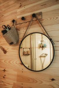 a mirror hanging on a wooden wall at Petite maison cosy Chez Georges in Auxonne