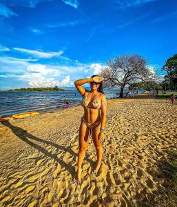a woman in a bikini standing on a beach at Fazenda Buritizal Grosso in Bonfim
