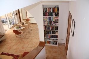 een kamer met een eettafel en een boekenplank gevuld met boeken bij Villa Kalisorate in Tsadha