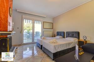 a bedroom with two beds and a balcony at SeafrontGardenHouse Villa in Iraklitsa