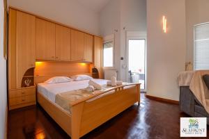 a bedroom with a large bed with a wooden headboard at SeafrontGardenHouse Villa in Iraklitsa